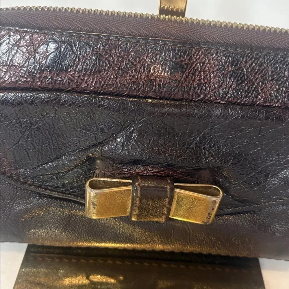 Chloe Lilly bow front long wallet in a metallic maroon brown
